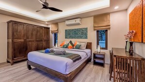 A bedroom with a bed, wooden wardrobe, air conditioning unit, and a small table with a vase. - Garden bungalows 4br with private pool (Rawai)