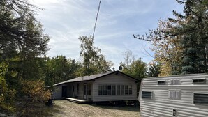 Une maison de plain-pied avec un porche à l’avant et une antenne parabolique.
