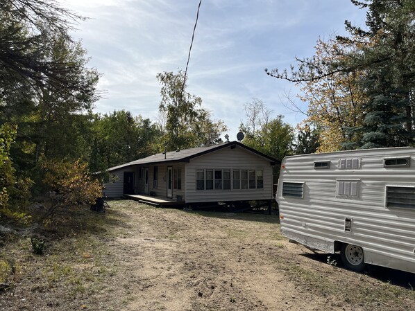 A single-story house with a front porch and a satellite dish. - Cozy cabin - Highlands of Belair (Bélair)