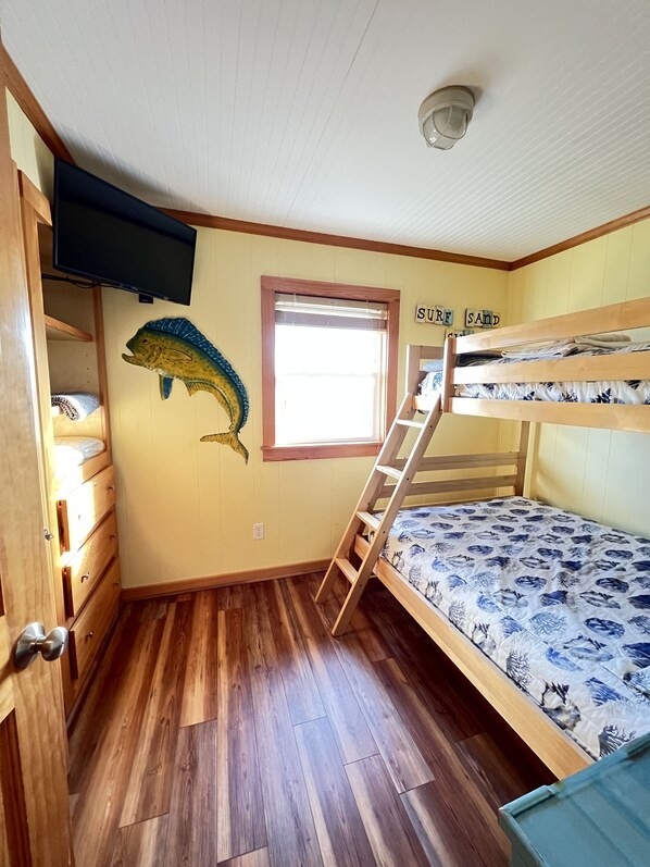 A bunk bed room with a wooden ladder, a fish mural, and a window with 'SURE SAND' letters. - Steps from the ocean in the Outer Banks - New Hot Tub, Deck & Dog Run! (Rodanthe)