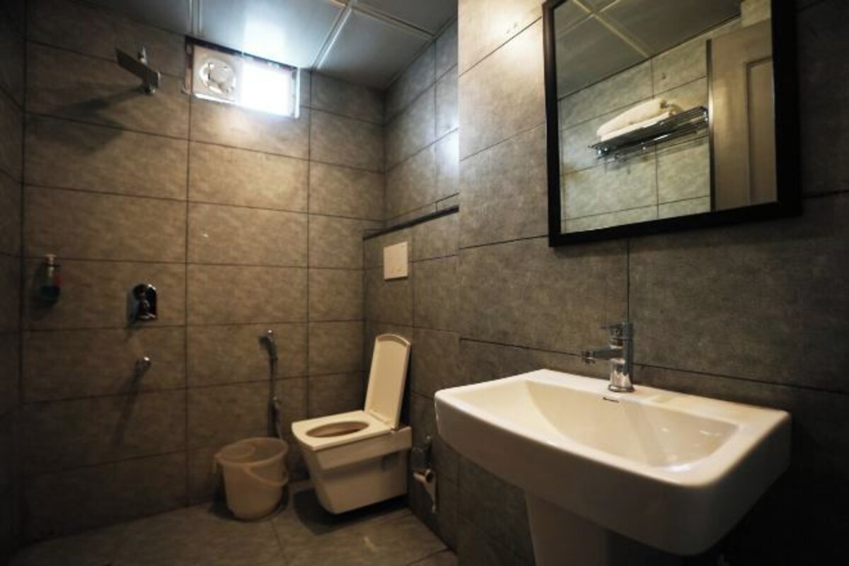 Ein kleines Badezimmer mit Toilette, Waschbecken und einem kleinen Spiegel.