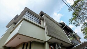 Un edificio moderno con tejado plano, ventanas amplias y unidad de aire acondicionado visible.