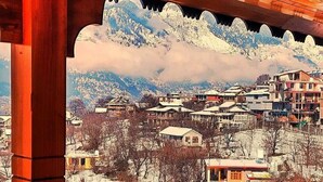 Un pueblo montañoso cubierto de nieve con edificios y barandilla de madera.