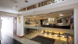 The entrance of Sunbow Hotel Residency with a reception desk, seating area, and a view of the interior through the glass doors. - Sungold Inn (Kuala Lumpur)