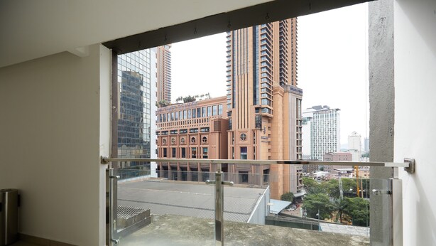 A high-rise building with a glass balcony, modern architecture, and a view of the cityscape. - Sungold Inn (Kuala Lumpur)