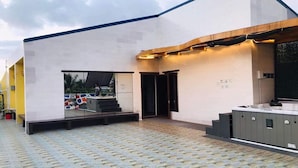 Un edificio moderno con techo plano, un espacio exterior cubierto y un jacuzzi.