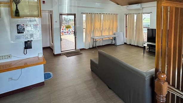 Un vestíbulo amplio con mostrador de recepción, zona de estar y escalera.