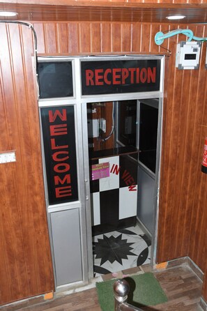 A reception area with a sign reading "RECEPTION" and "WELCOME". - Hotel Mountain View And Rooftop Restaurant (Pithoragarh)