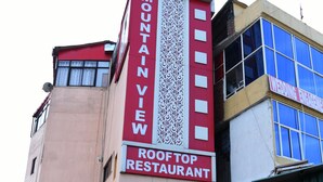 A hotel with a prominent sign indicating it is the "MUNANYEW HOTEL ROOFTOP RESTAURANT." - Hotel Mountain View And Rooftop Restaurant (Pithoragarh)