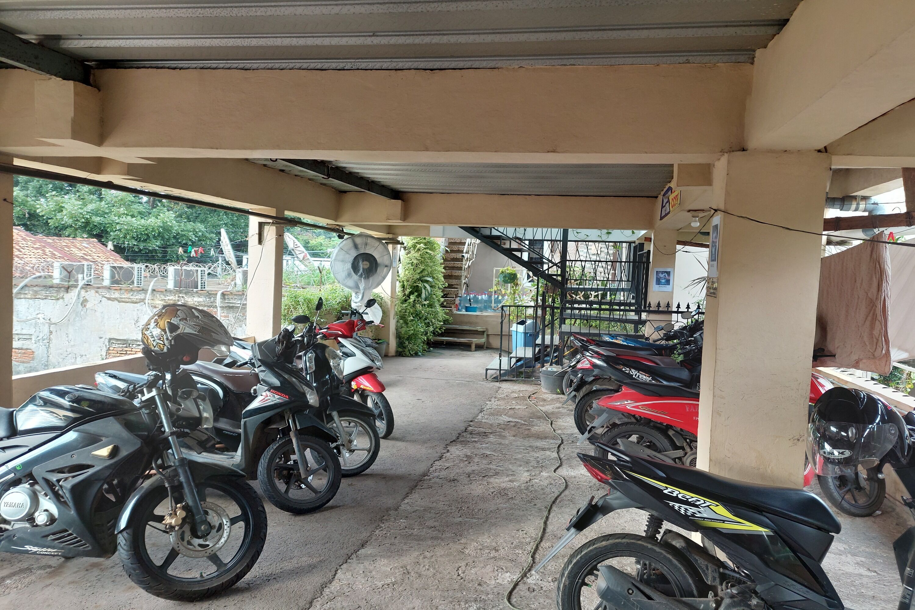 Un área de estacionamiento techada con motocicletas y scooters aparcados.