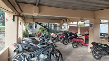Un espace de stationnement couvert où sont garées plusieurs motos.