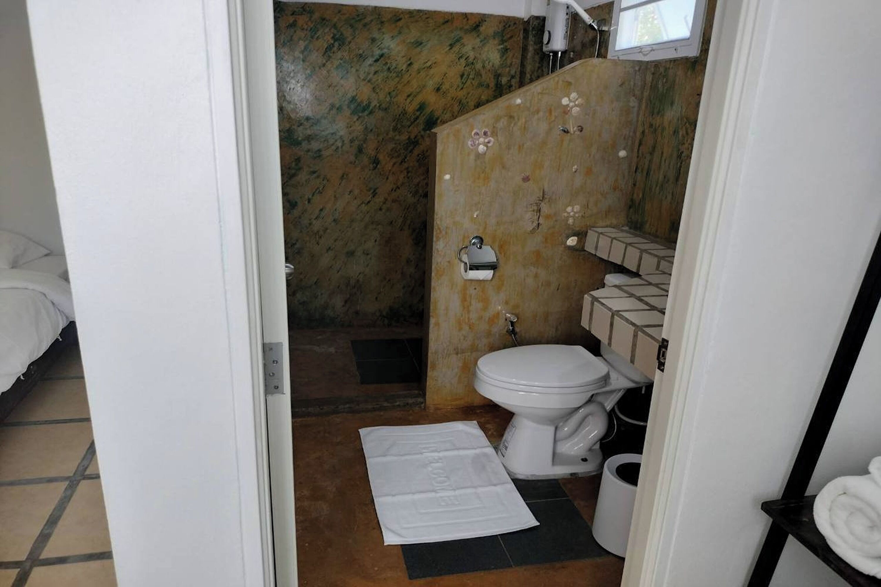 A bathroom with a toilet, a sink, and a shower area.
