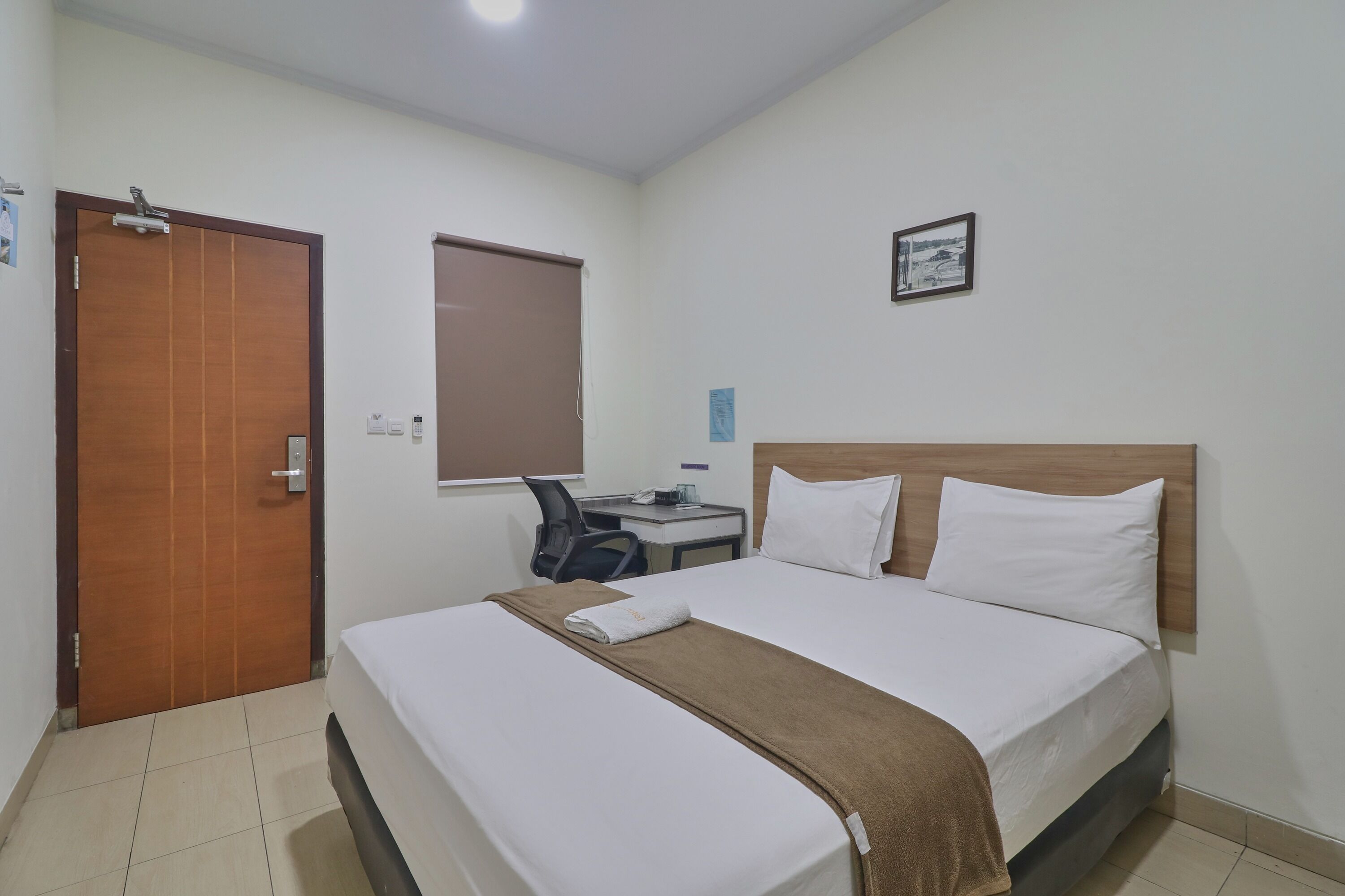 Een hotelkamer met een bed, een bureau en een stoel.
