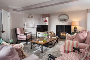 A cozy living room with a fireplace, a television, and a coffee table with decorative items.