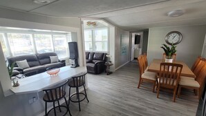 A modern living space with a dining area, a kitchen, and a living room. - 4 Bedroom Farmhouse On The River 2 (Spring Hill)