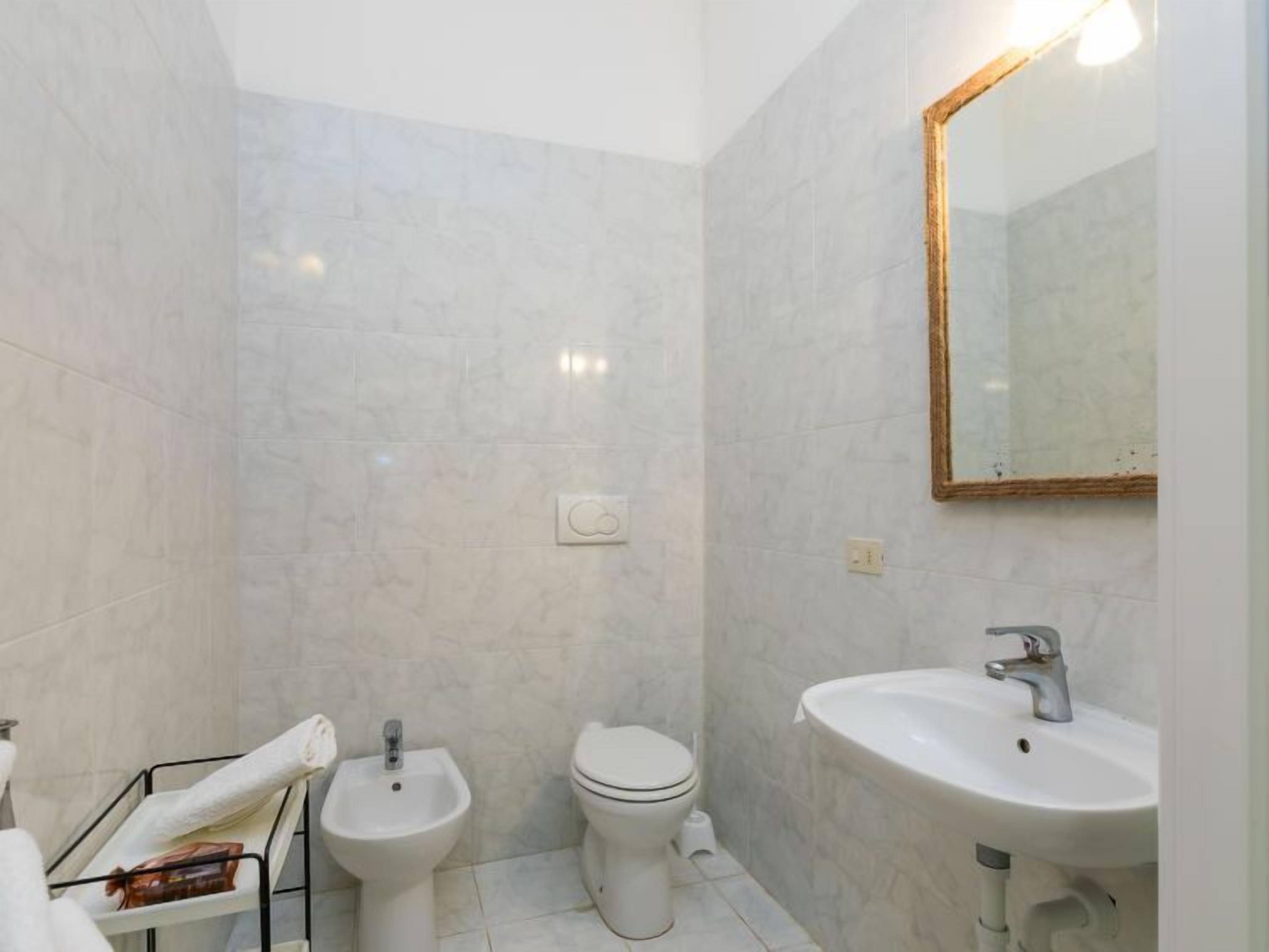 Un baño con bidé, inodoro y lavabo.
