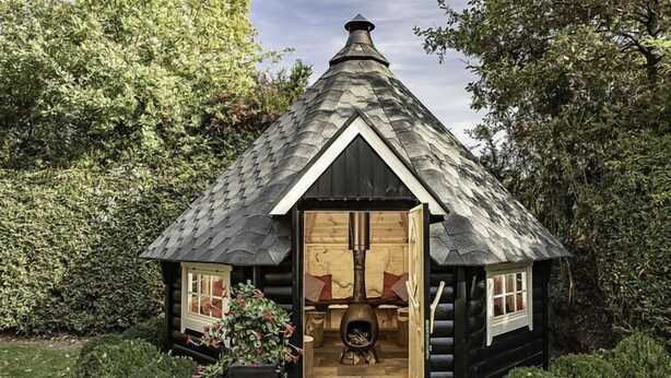 A log cabin with a wooden door, a chimney, and a small window. - Familieboerderij by Interhome (Losser)