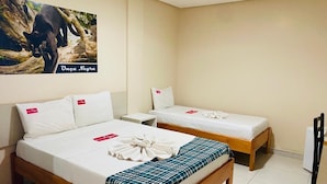 A hotel room with two single beds, a wooden headboard, a white wall, and a poster of a black panther.