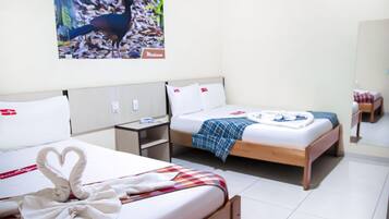 Een hotelkamer met twee bedden, een nachtkastje, een aan de muur bevestigde televisie en een spiegel.