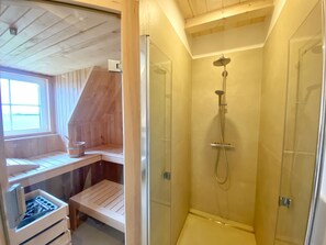 A small, wooden room with a glass shower enclosure, a wooden bench, and a window. - Vacation home "Distelfink" in Dranske / Lancken - thatched roof house with Bodden view, (Dranske)