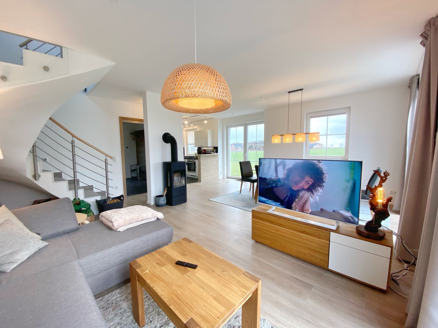 A modern living room with a sofa, coffee table, TV, and a fireplace.