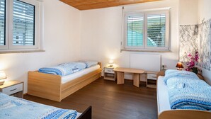 A bedroom with two beds, a wooden ceiling, and two windows with blinds. - Holiday Apartment 'Nguyen Und Le 2' with Wi-Fi (Neukirch)