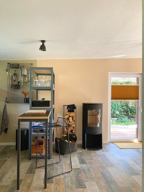 A kitchen with a built-in stove, a metal shelving unit, and a dining table.