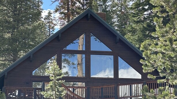 A cabin with a wooden exterior, large windows, and a balcony. - Sunrise Kirkwood Chalet with Red Cliffs View (Kirkwood)
