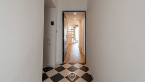 A hallway with a checkered floor leading to a staircase. - Luisa Apartment (Cagliari)