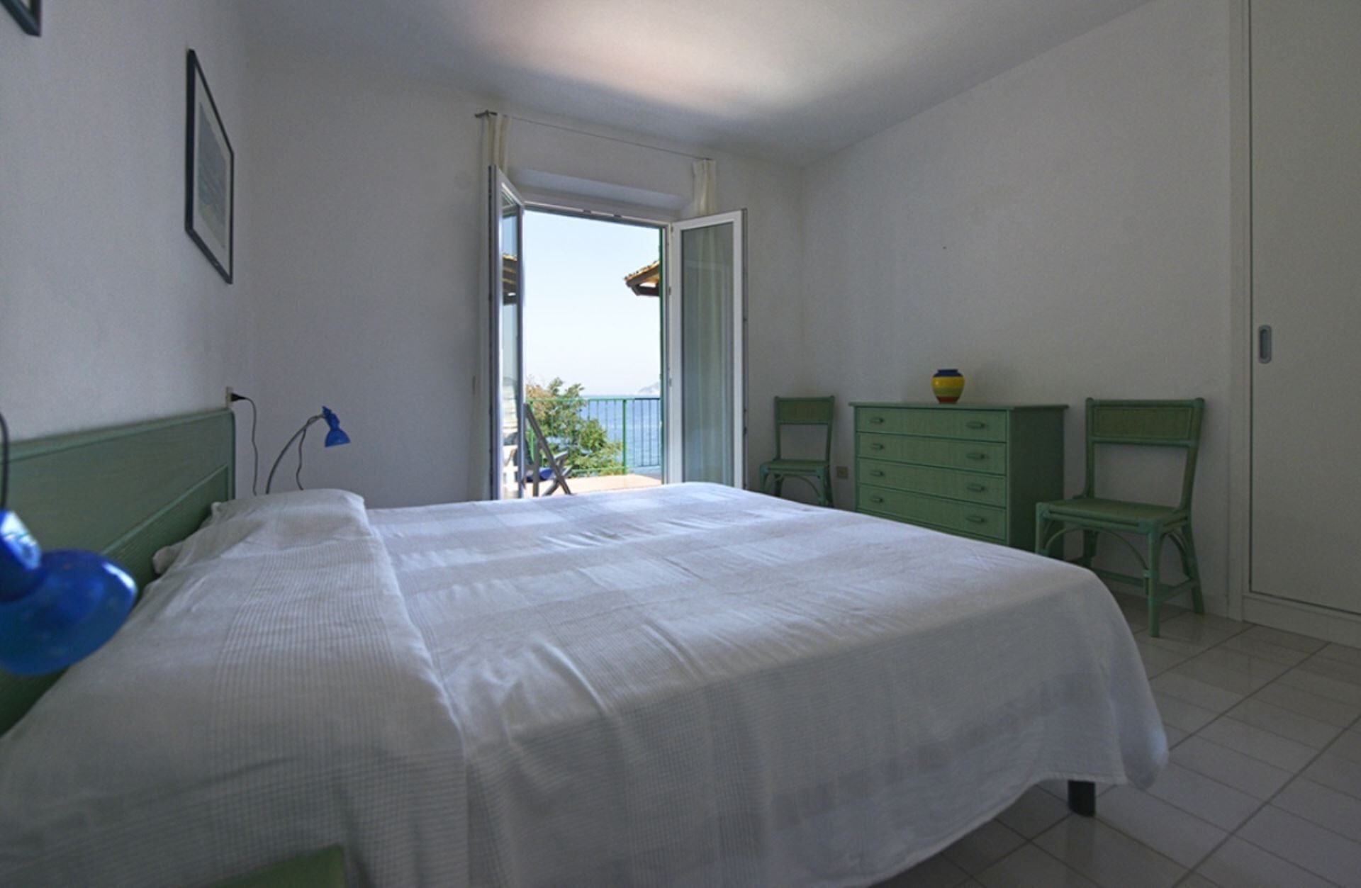 A bedroom with a bed, a dresser, a chair, and a desk.