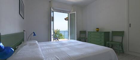 A bedroom with a bed, a dresser, a chair, and a desk.