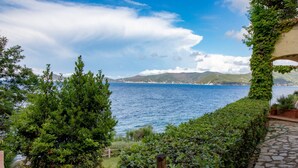 Une vue sur la côte, avec un sentier en pierre menant à un jardin luxuriant.