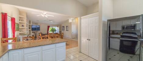A modern kitchen with white cabinets, a granite countertop, and stainless steel appliances.
