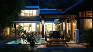 A modern house with a swimming pool, outdoor seating, and a covered patio area. - Emerald Sands  Beach Villa with Pool (Koh Samui)