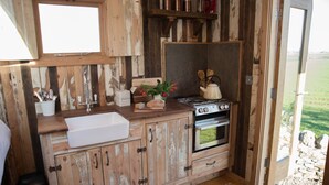 A rustic kitchen with a wooden countertop, a sink, a stove, and cabinets. - The Sanderling  - sleeps 2 guests  in 1 bedroom (Beadnell)