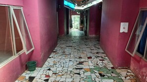 A corridor with a tiled floor and pink walls. - OYO 90555 Vina Pavilion (Bengkulu)