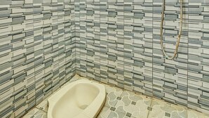 A small bathroom with a toilet, a shower, and tiled walls. - SPOT ON 91715 Hotel Citra Dewi 1 (Bandungan)