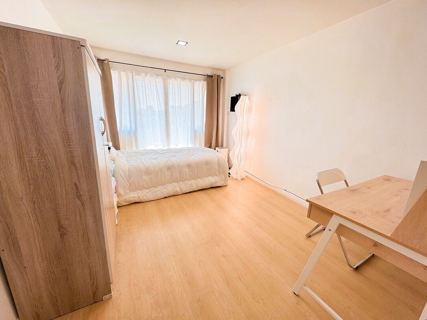 Une chambre à coucher avec un lit, un bureau et une chaise.