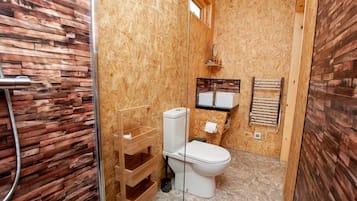 Une petite salle de bain comprenant des toilettes, un lavabo et une douche.