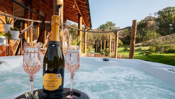 Ein Whirlpool mit einer Prosecco-Flasche und zwei Gläsern.