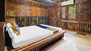 A bed with a wooden frame and a white mattress, a wooden headboard, and a bamboo wall panel. - OYO 92083 Lailik Gilang Guesthouse (Werinama)