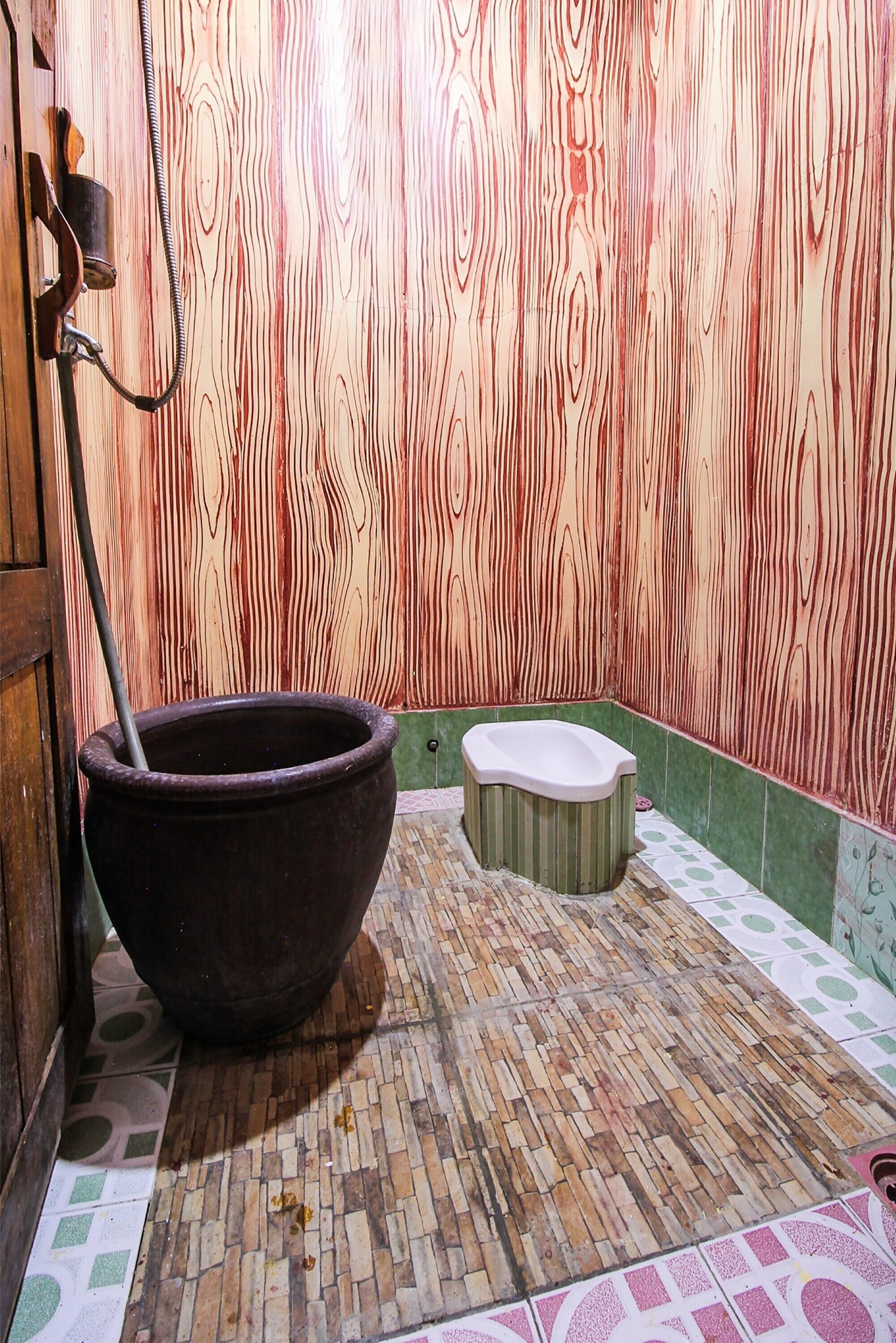 A bathroom with a large wooden bath tub, a toilet, and a shower area.