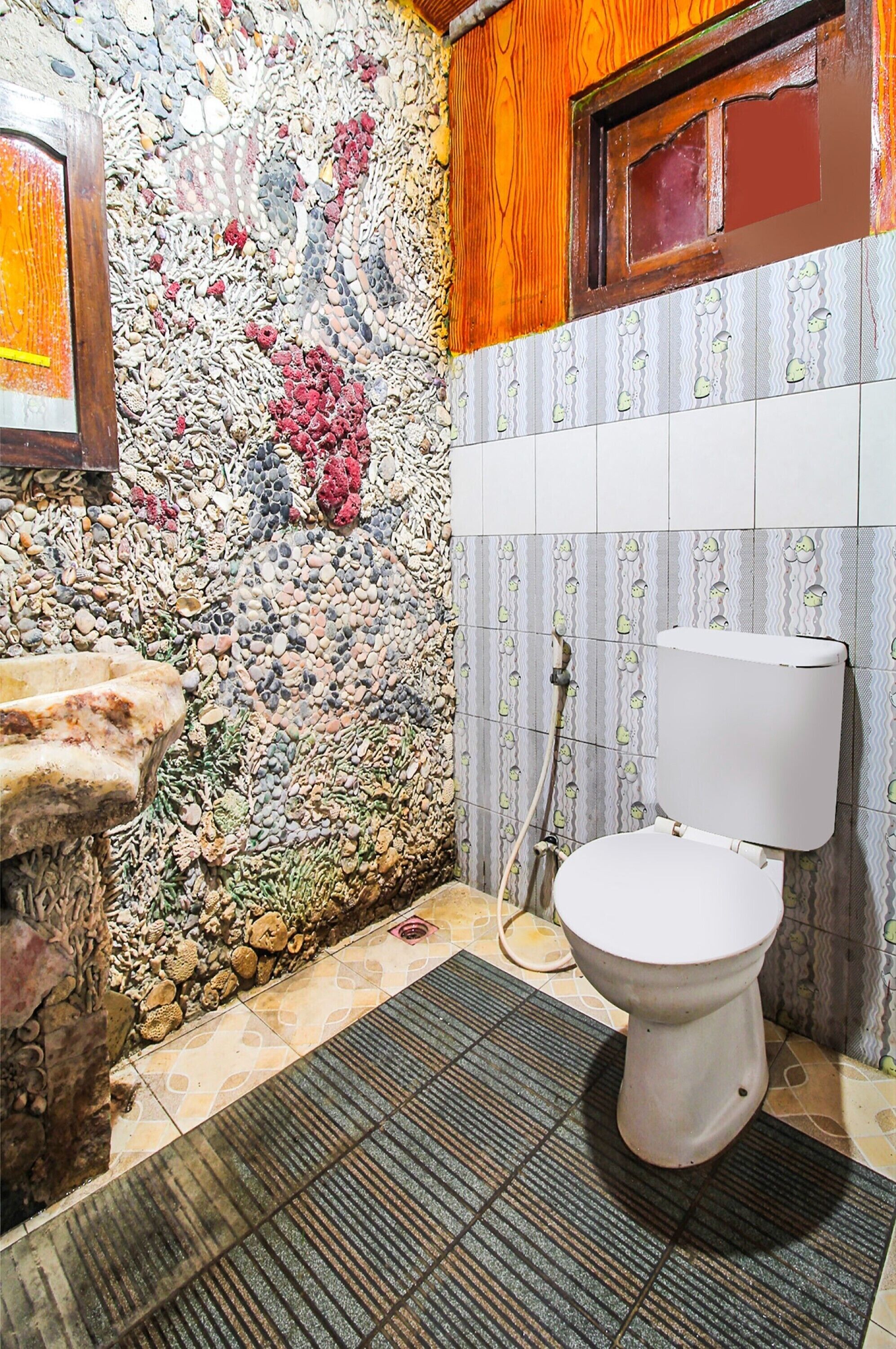 A bathroom with a stone wall, a toilet, and a tiled floor.