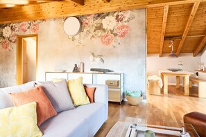 A cozy living room with a sofa, a coffee table, and a dining area with a table and chairs.