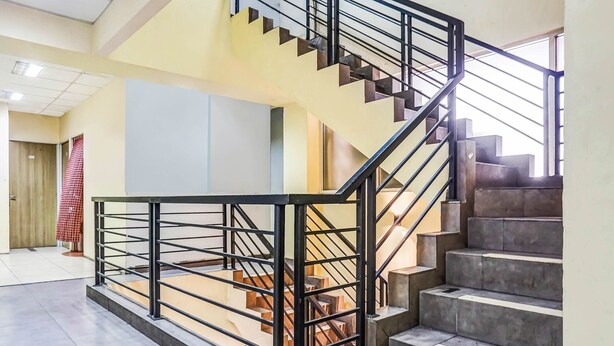 A modern interior with a staircase, metal railings, and a tiled floor.