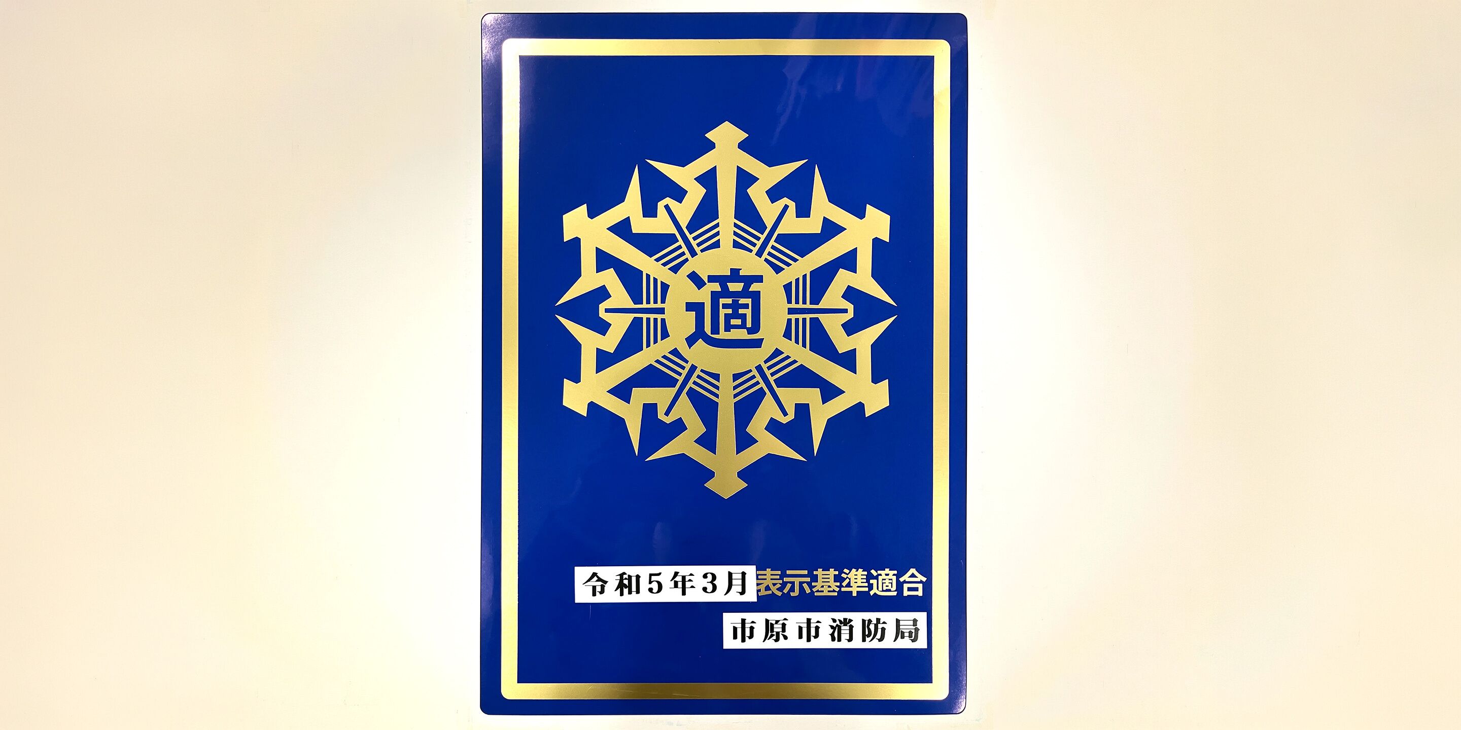 A blue sign with gold text and a geometric design.