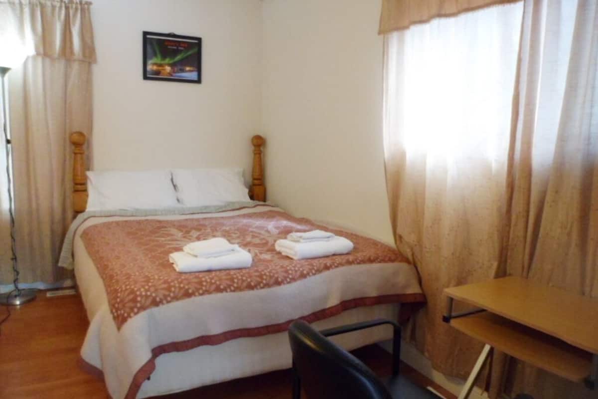 Une chambre à coucher avec un lit, un bureau et une chaise.