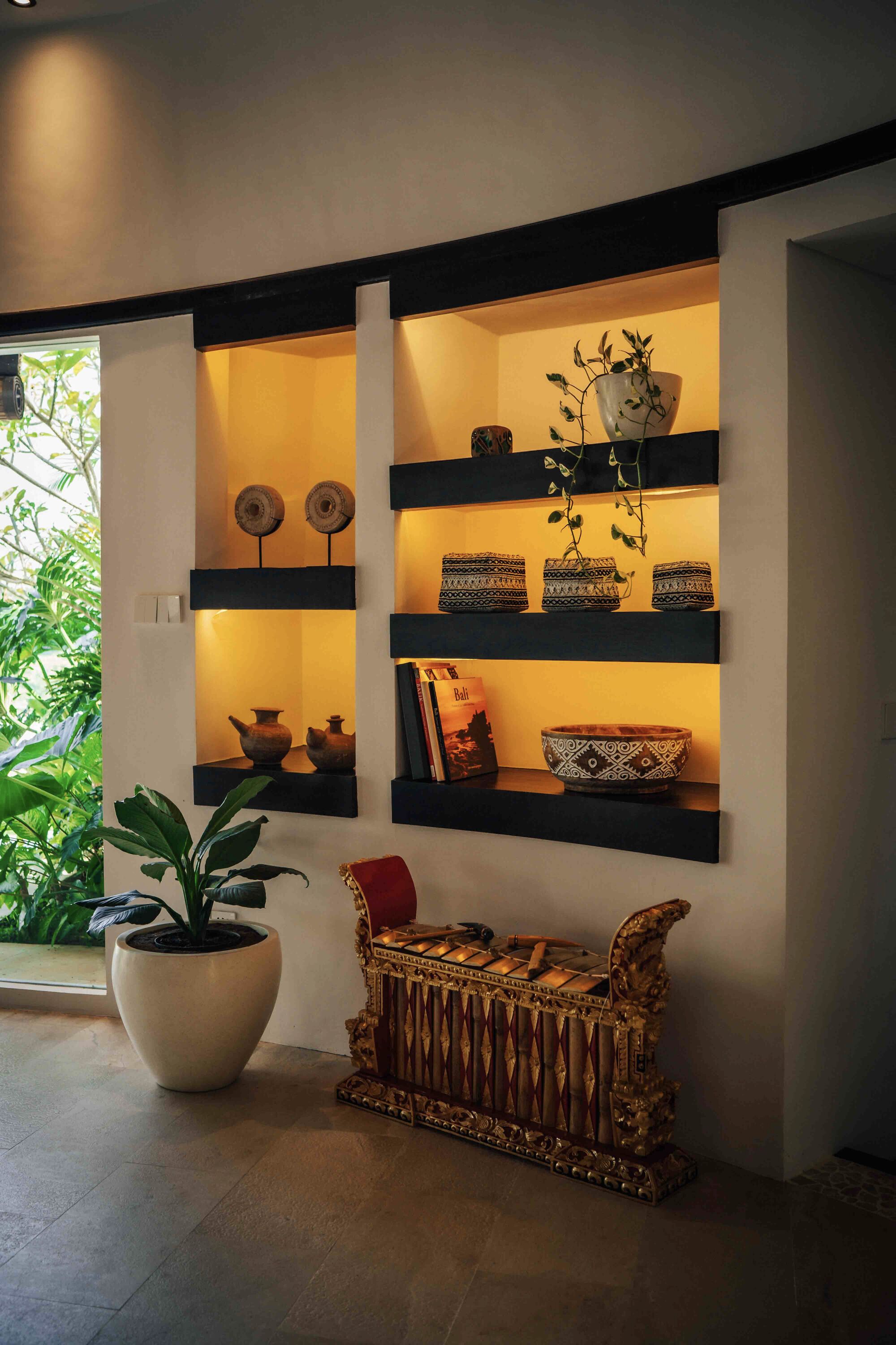 A wall-mounted shelf unit with decorative items and a potted plant.