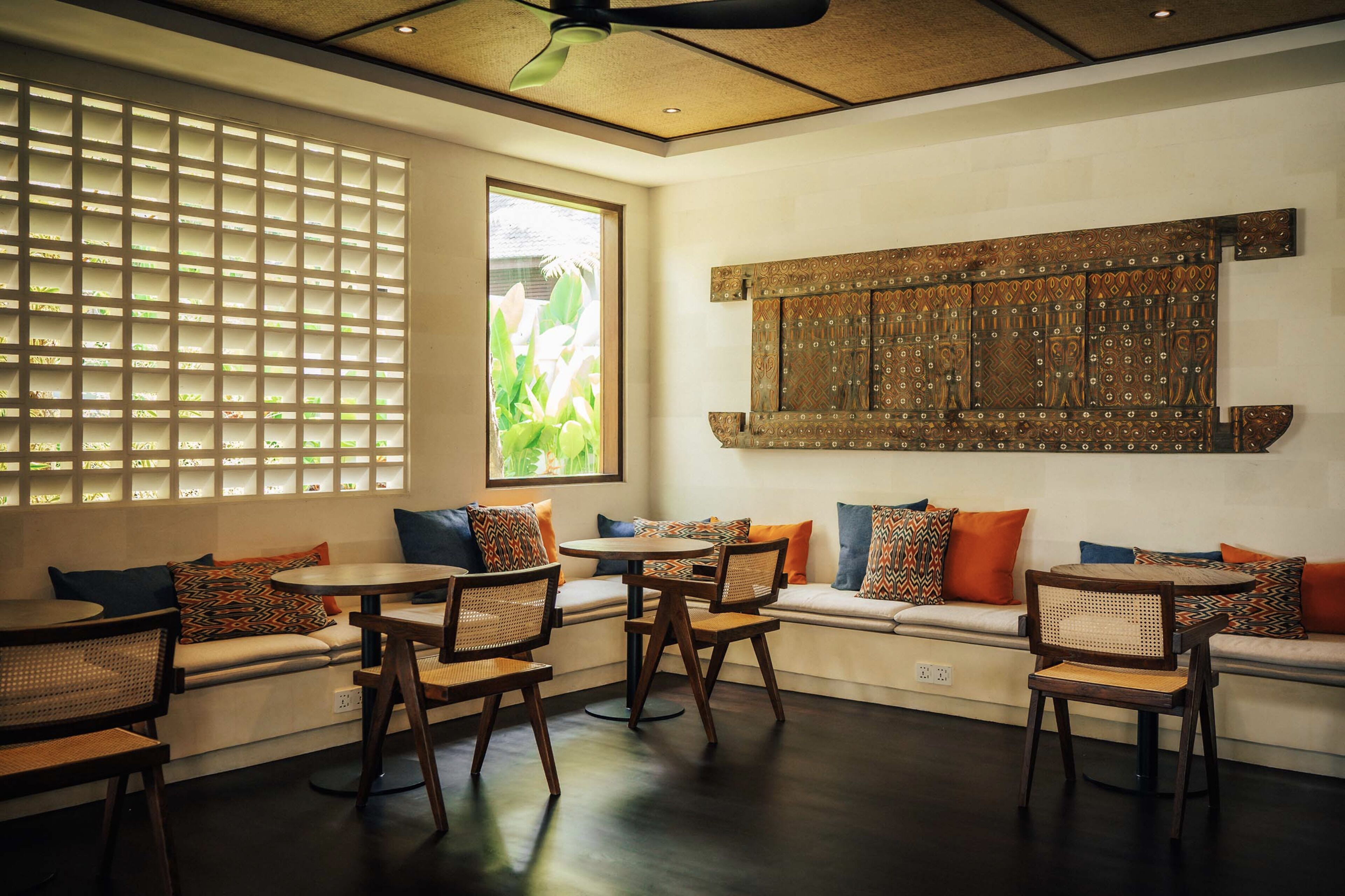 Un interior moderno con una zona de estar, muebles de madera y un panel decorativo en la pared.