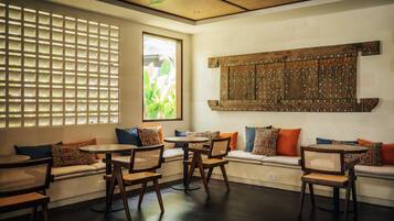 Un interior moderno con una zona de estar, muebles de madera y un panel decorativo en la pared.